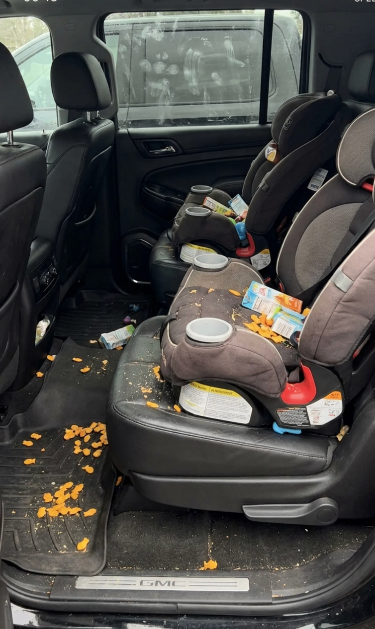 Family GMC interior before Eleavar detailing, with crumbs, child seats, and debris